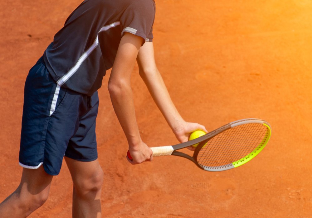 Joueur de tennis au service sur terre battue